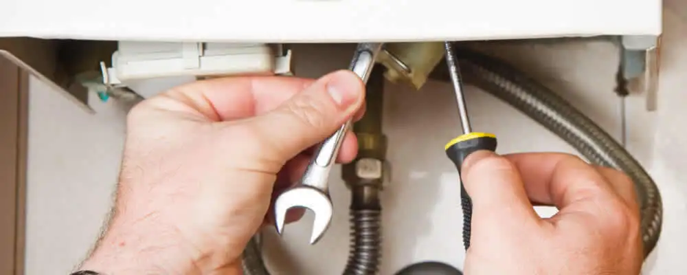 Boiler repair technician tightening pipe fittings and connections in Kissimmee, FL