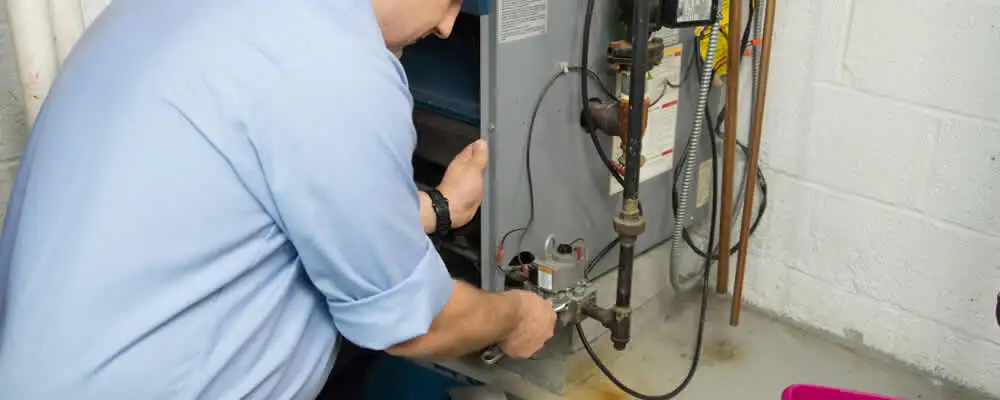 Furnace repair technician inspecting and servicing a home heating system in Kissimmee, FL
