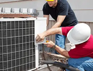 HVAC technicians repairing an outdoor AC unit on a rooftop in Kissimmee, FL