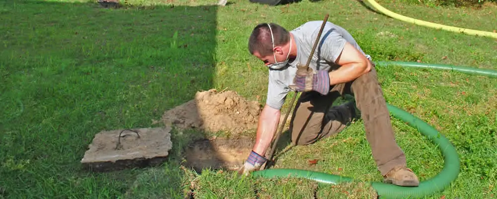 Septic pumping technician servicing a residential septic tank in Kissimmee, FL