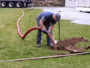 Septic pumping technician servicing a residential septic tank with a vacuum hose in Kissimmee, FL