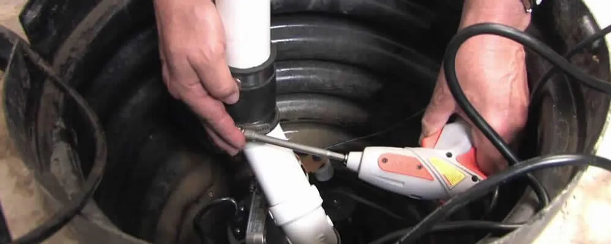 Sump pump installation technician connecting PVC discharge piping in Kissimmee, FL