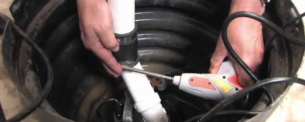 Sump pump installation technician connecting PVC discharge piping in Kissimmee, FL
