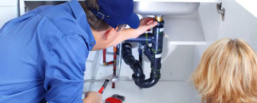Plumber repairing under-sink drain pipes and fittings in Kissimmee, FL